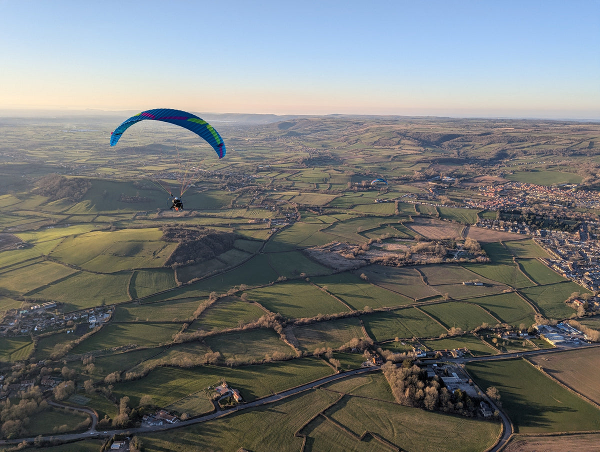 Paramotor pilot flying an Ozone Roadster 4 reflex wing over the Somerset levels near the Bath and West Showground.
